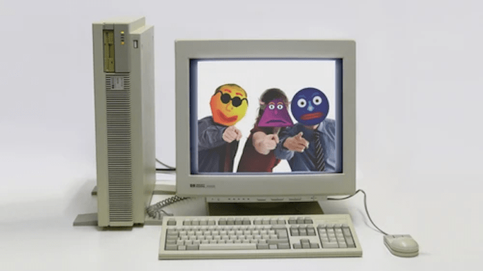a stock image of a VERY old computer. On the monitor are three people pointing at the viewer. Their heads have been replaced with Snood cartoon faces.